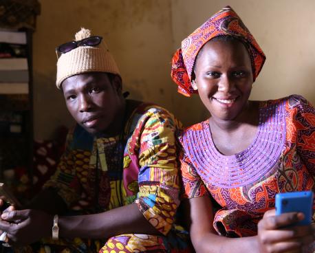 UN in Action section banner showing a man and woman with a mobile phone.