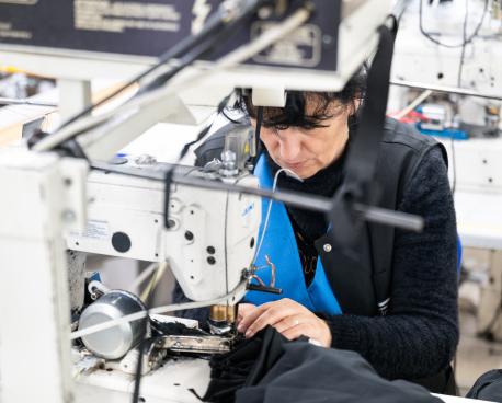 A woman uses a sewing machine while at work.