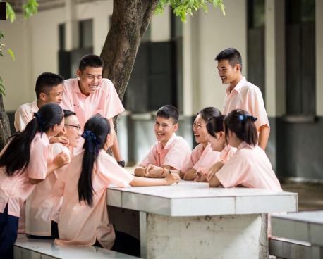 A group of young women and men sitting together and laughing