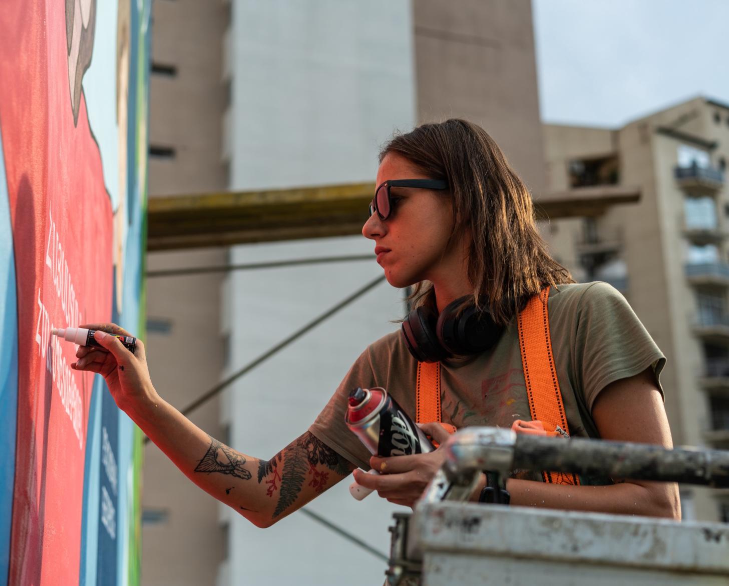 Musya Qeburia works on a mural in Tbilisi, Georgia