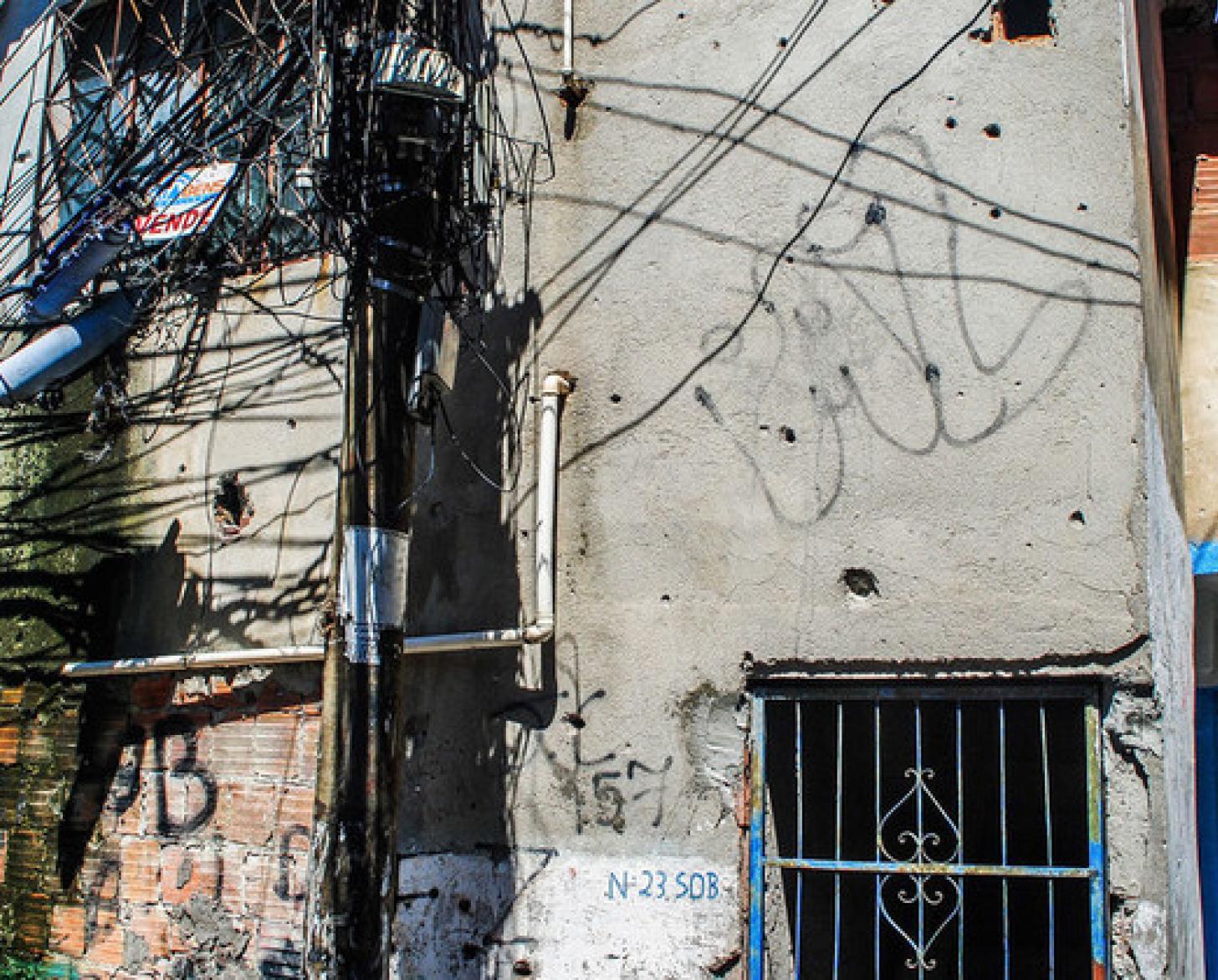 The walls of a home shot multiple times displays the word peace.
