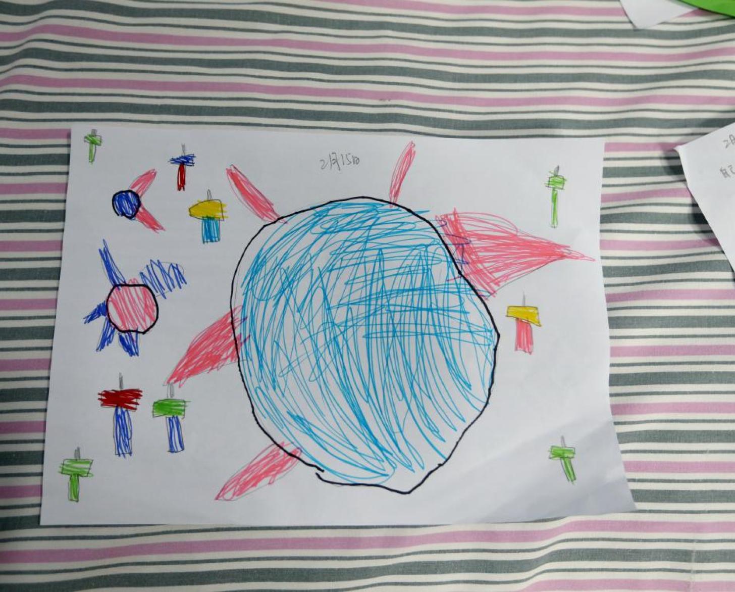 Dessin d'enfant représentant le coronavirus entouré de marteaux.
