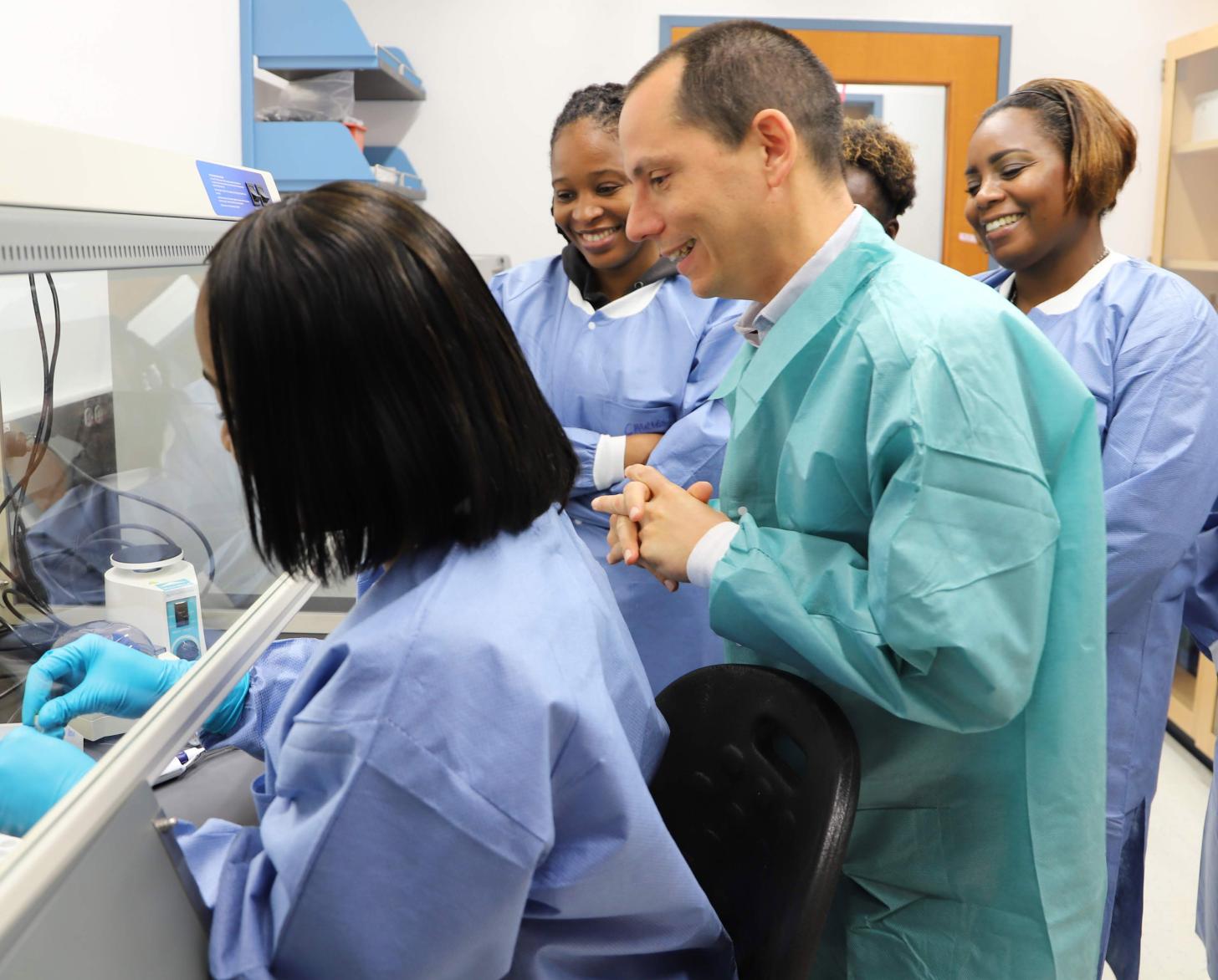 Laboratory Technologist being observed by Dr Gresh, Laboratory Director and other colleagues.
