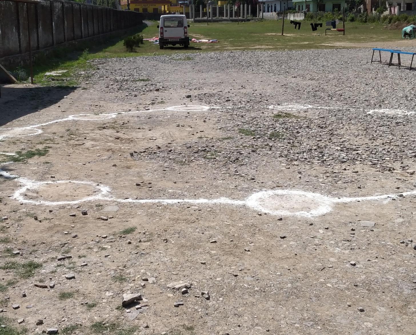 Círculos dibujados en el suelo para ayudar a los trabajadores sanitarios a mantener la distancia entre ellos en un centro de cuarentena del distrito de Rupandehi, en el oeste de Nepal. UNICEF, junto con el gobierno y otros asociados, ha participado en visitas a diferentes centros de cuarentena como éste para evaluar las condiciones, centrándose en las instalaciones de agua, saneamiento e higiene y en cuestiones de protección.