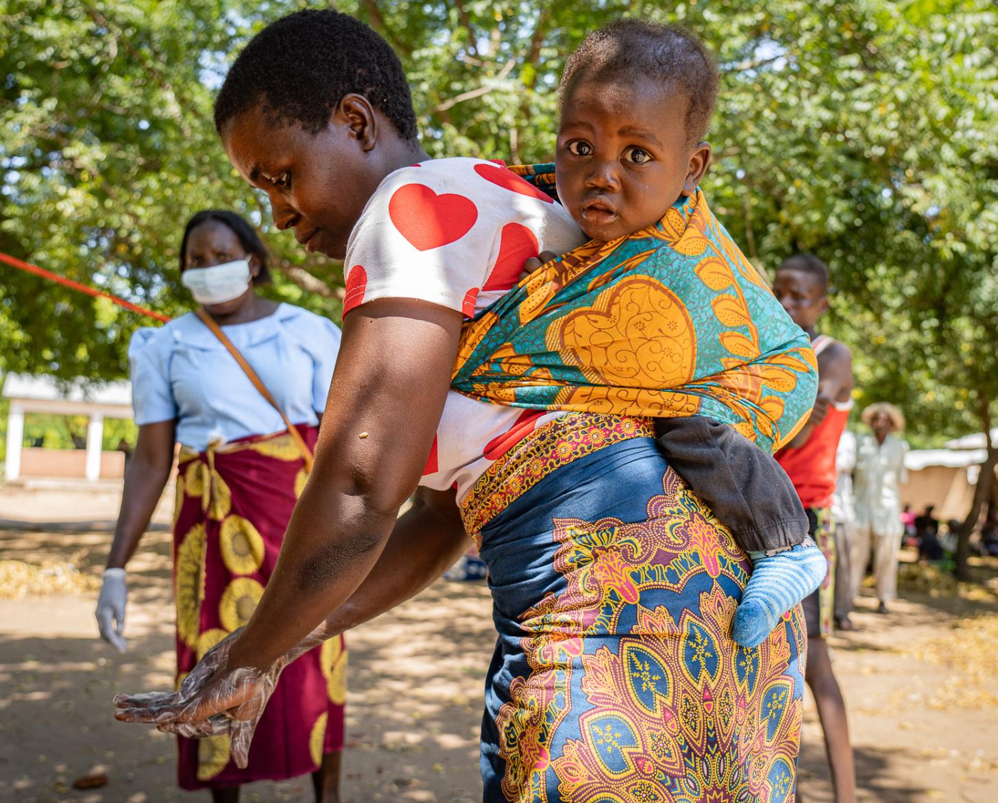 Alinafe Nhlane, a subsistence farmer, is shown washing her hands with her baby.