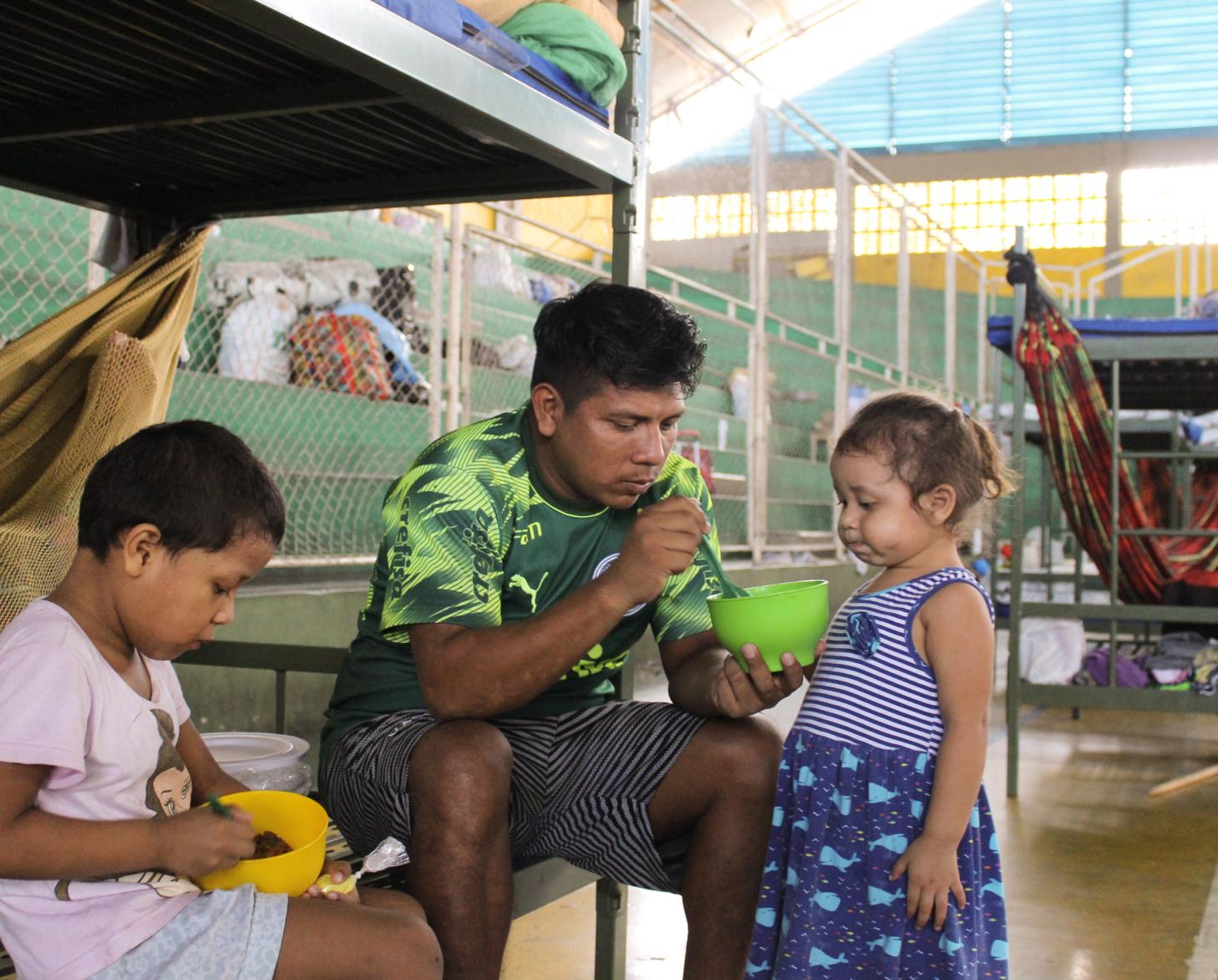 IOM distributed essentials to the shelters in Brazil housing refugees from Venezuela. A family staying at the shelter eat together. 
