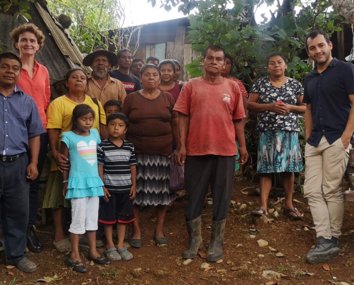  Des hommes, des femmes et des enfants se tiennent debout, face caméra, sous un arbre, dans le territoire luxuriant de la province de Puntarenas.