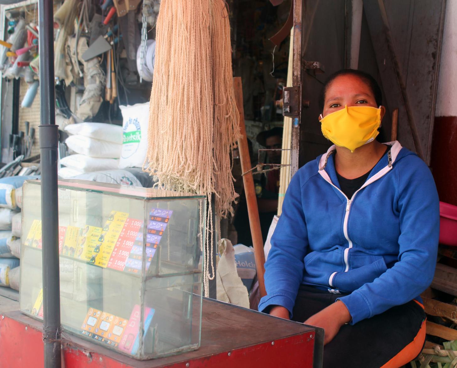 A woman is shown wearing a protective mask at the small shop she runs at the market in Antananarivo, Madagascar.