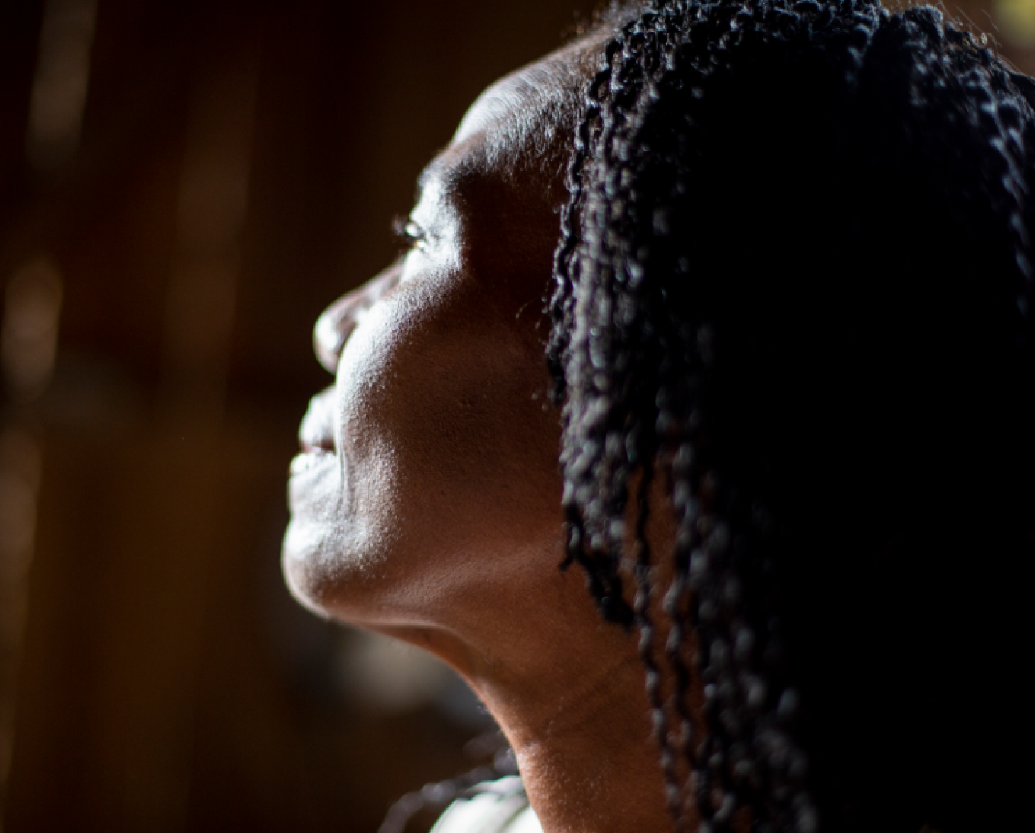 The profile of a woman's face as she stares out pensively. 