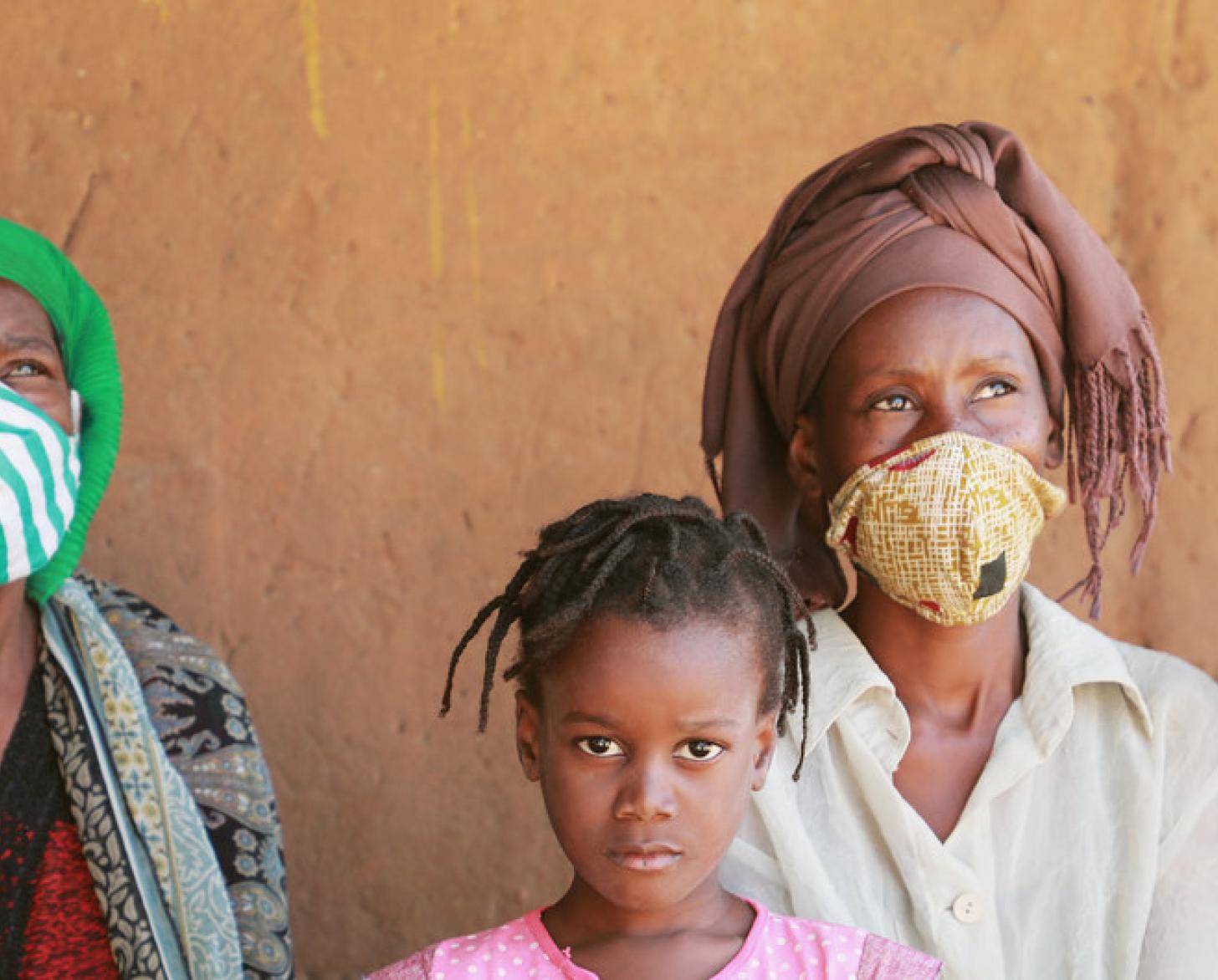 Mujeres y niñas desplazadas internamente frente a un muro en el barrio de Alto Gingone, Pemba, provincia de Cabo Delgado.