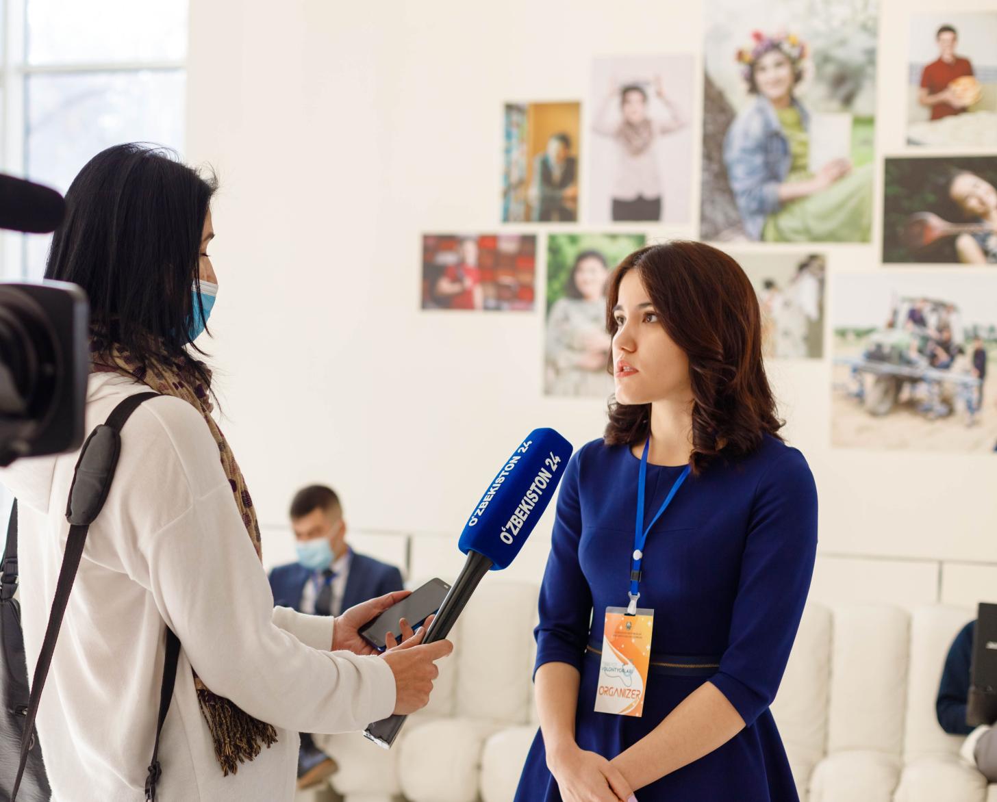 Молодая женщина отвечает на вопросы телерепортера. 