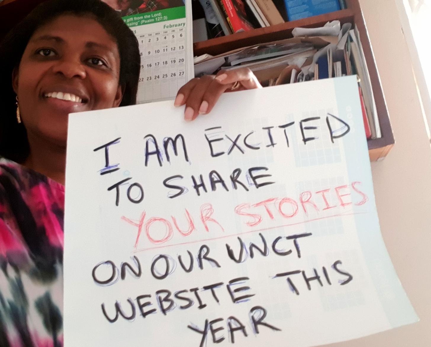 Cynthia Prah of UN Ghana proudly holds up a sign that reads, " I am excited to share your stories on our UNCT website this year!"