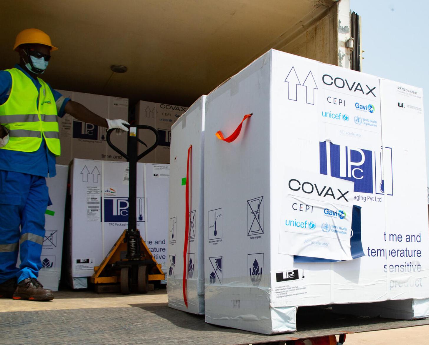 Photo shows a warehouse staff member proudly unloading boxes of vaccines from a truck.