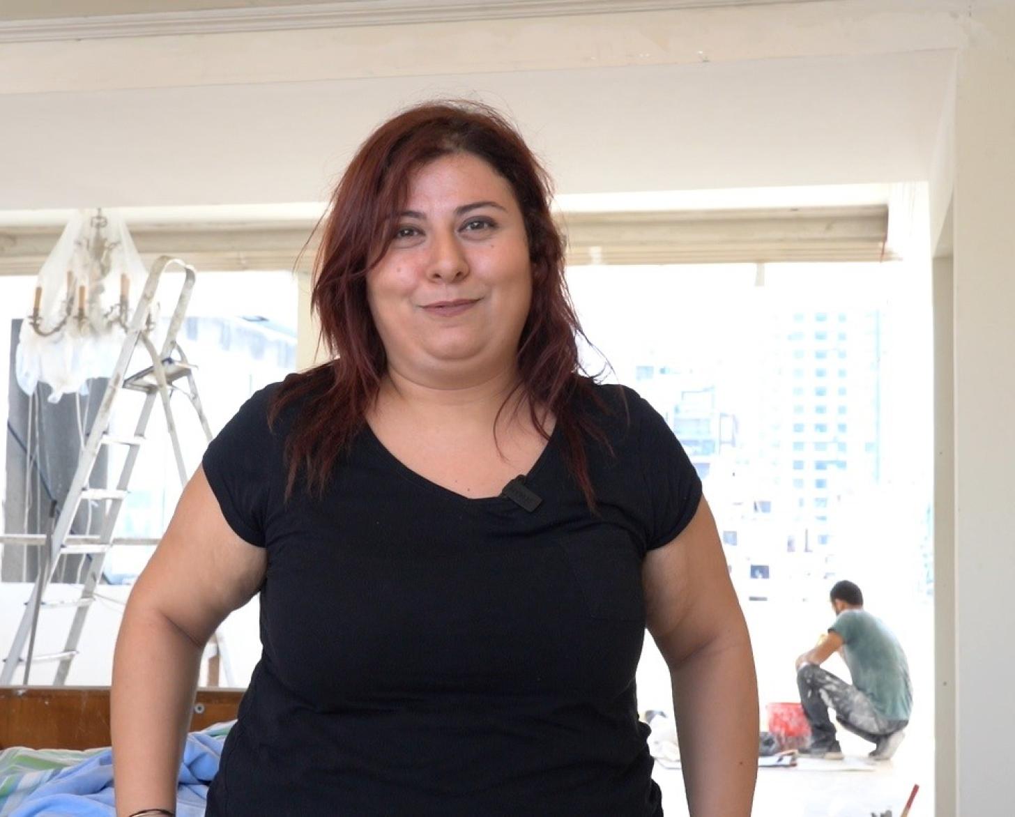 A woman in a black shirt looks at the camera.