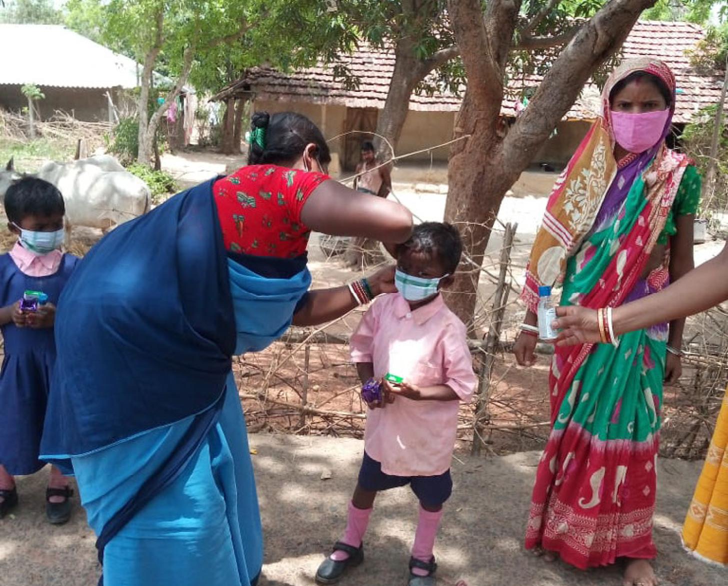A woman examens a little girl outside. 