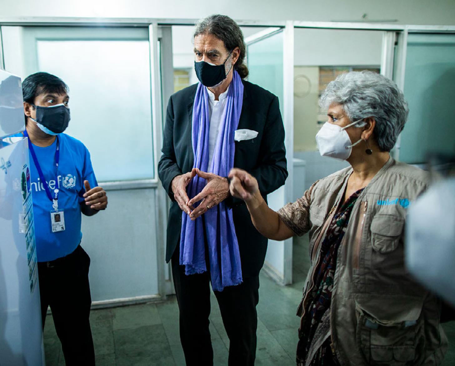 United Nations staff and the ambassador to India from Germany look at some of the supplies donated from Germany in India. 