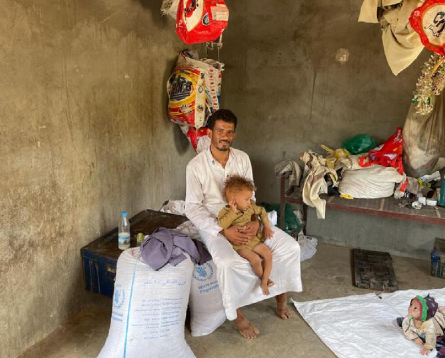 Un hombre está sentado, sonriendo, con sus dos hijos.
