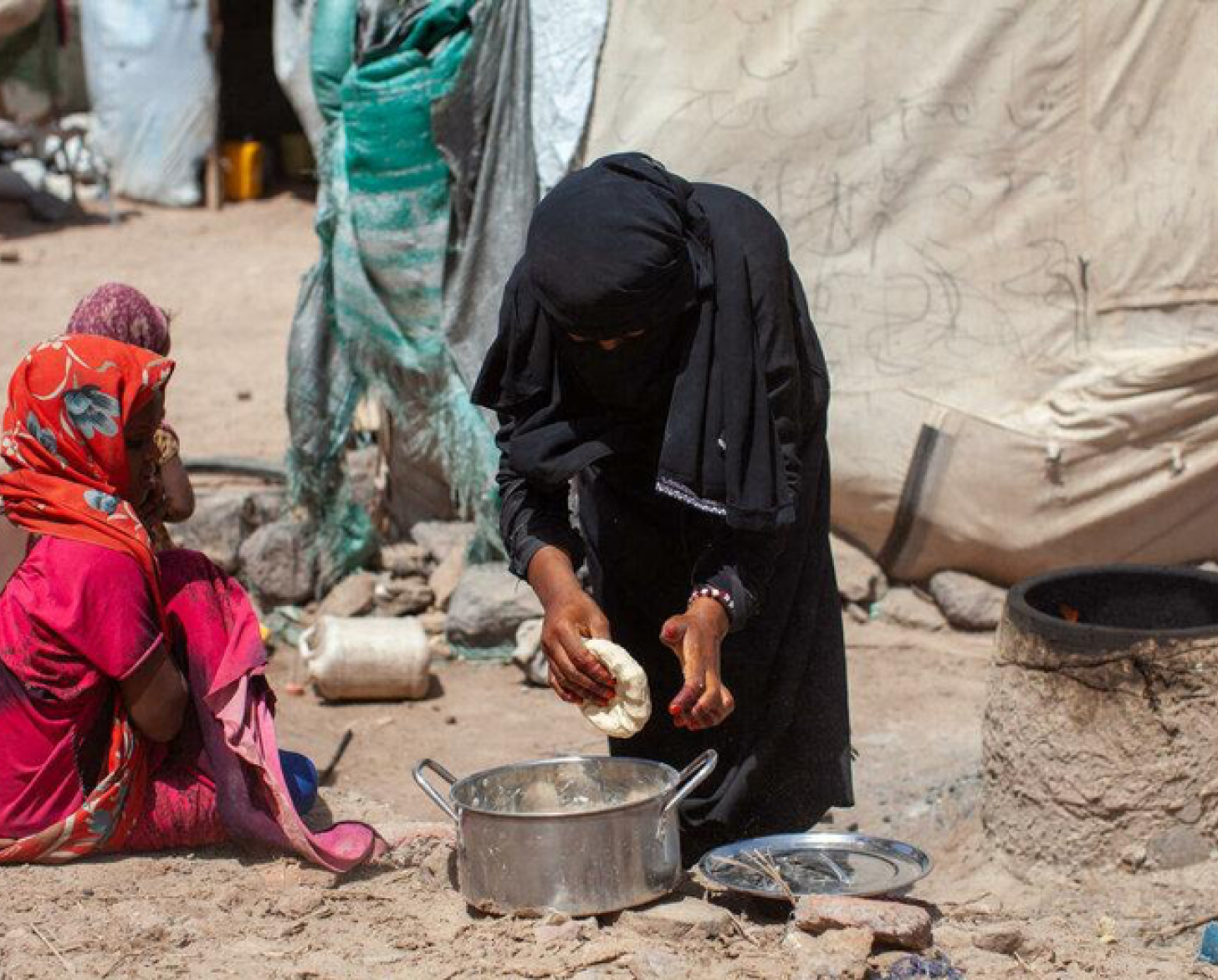 Una mujer se inclina sobre una olla.
