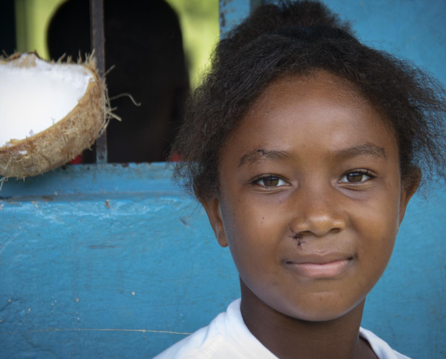 Portrait en gros plan d'une jeune écolière souriant face caméra. 