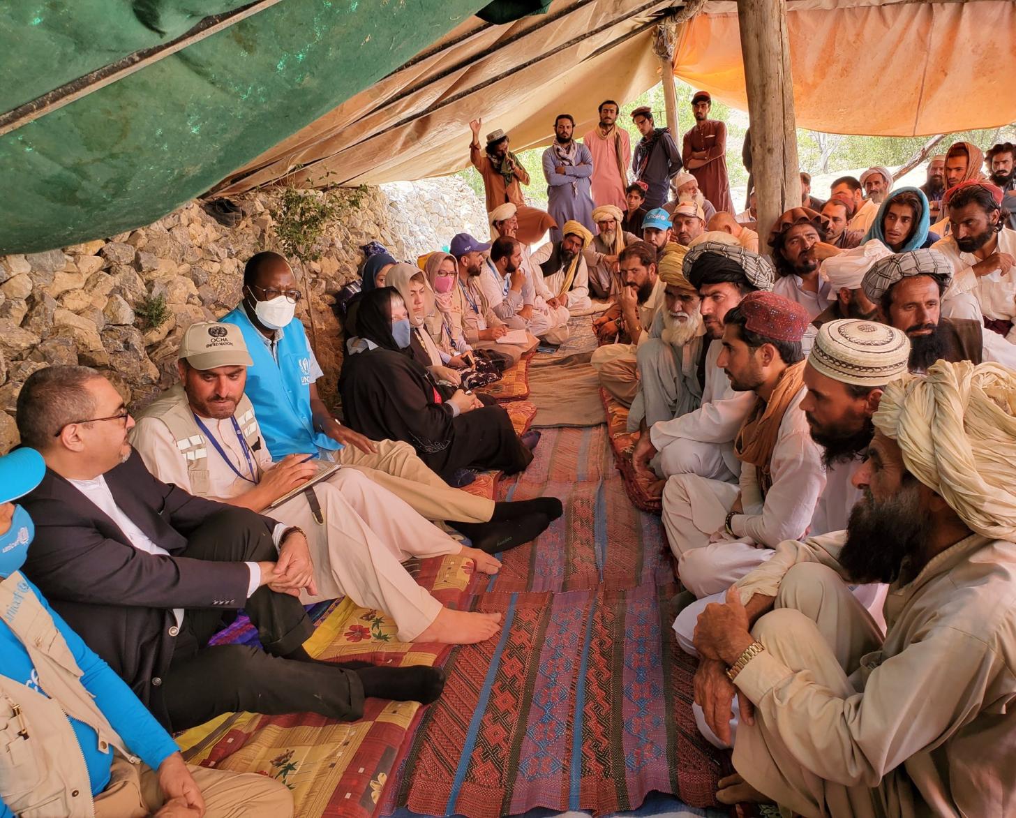 الدكتور رامز يجلس مع أهالي قرية ووري كاليا في خيمة.