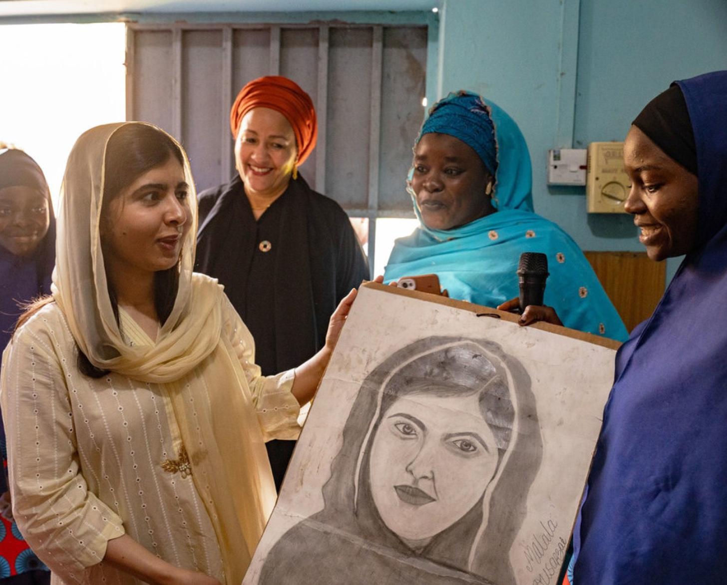 Malala Yousafzai receives a photo as Deputy Secretary-General Amina J. Mohammed looks on