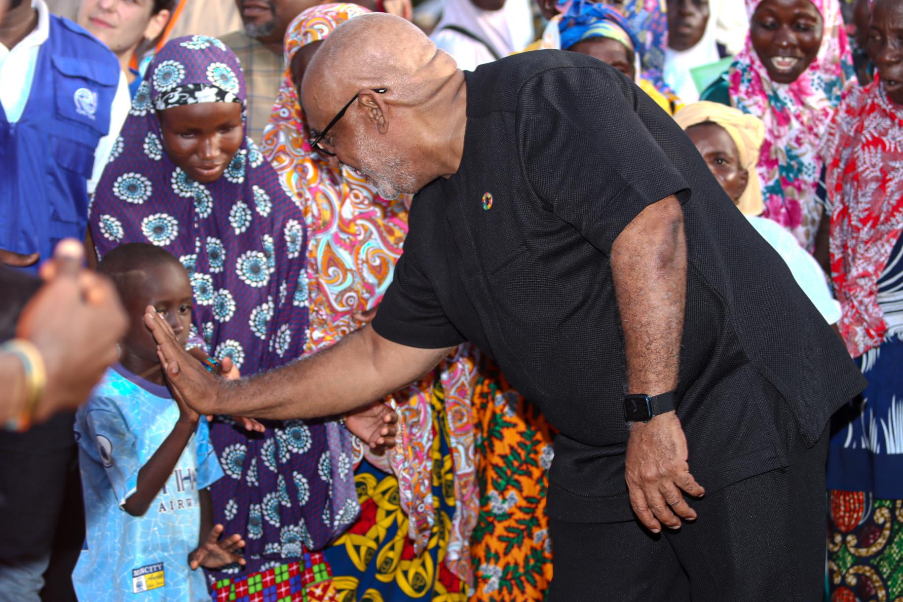 UN RC in Ghana Charles Abani interacts with a child at the Tarikom resettlement centre 