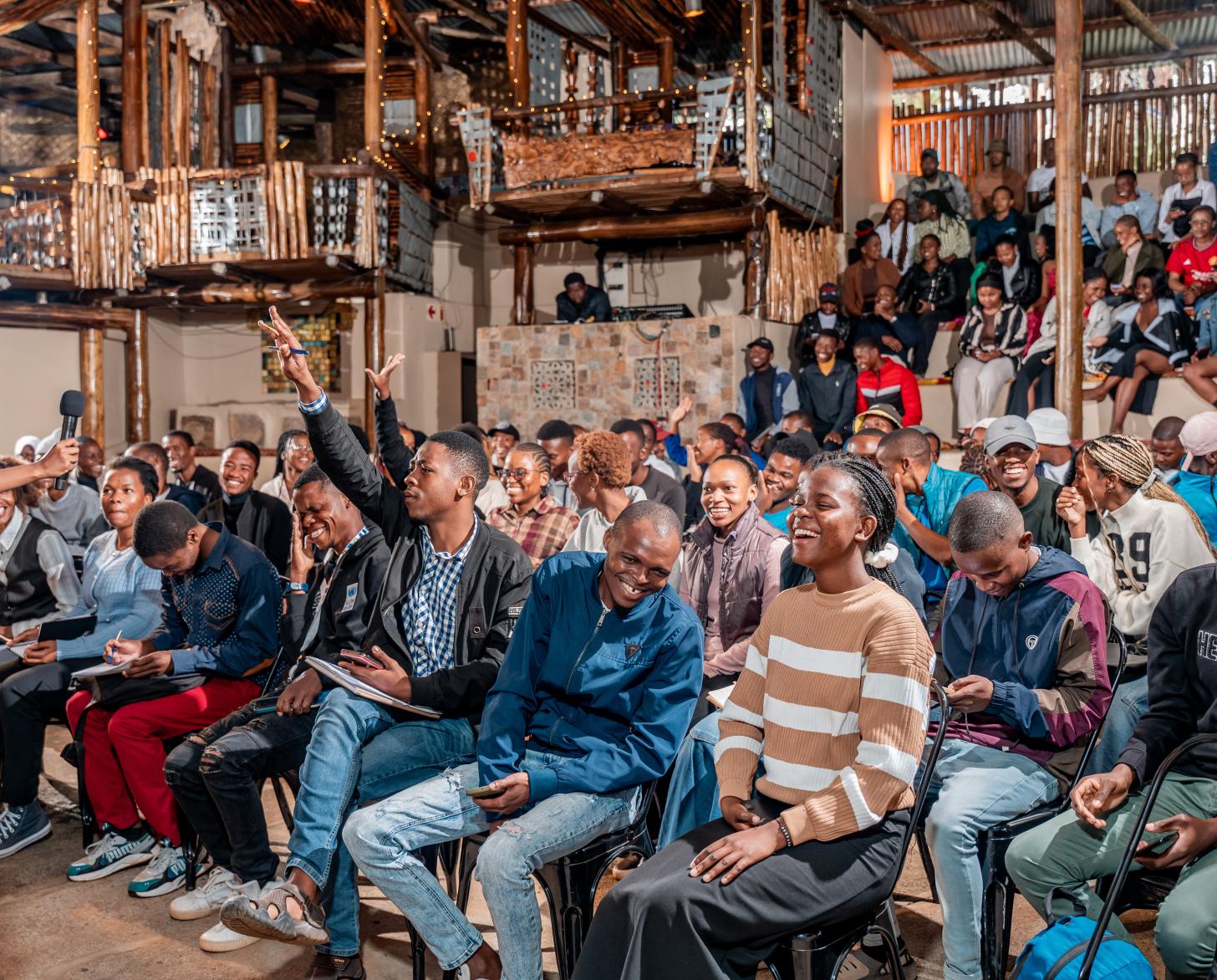 A large audience of young people, some with their hands raised