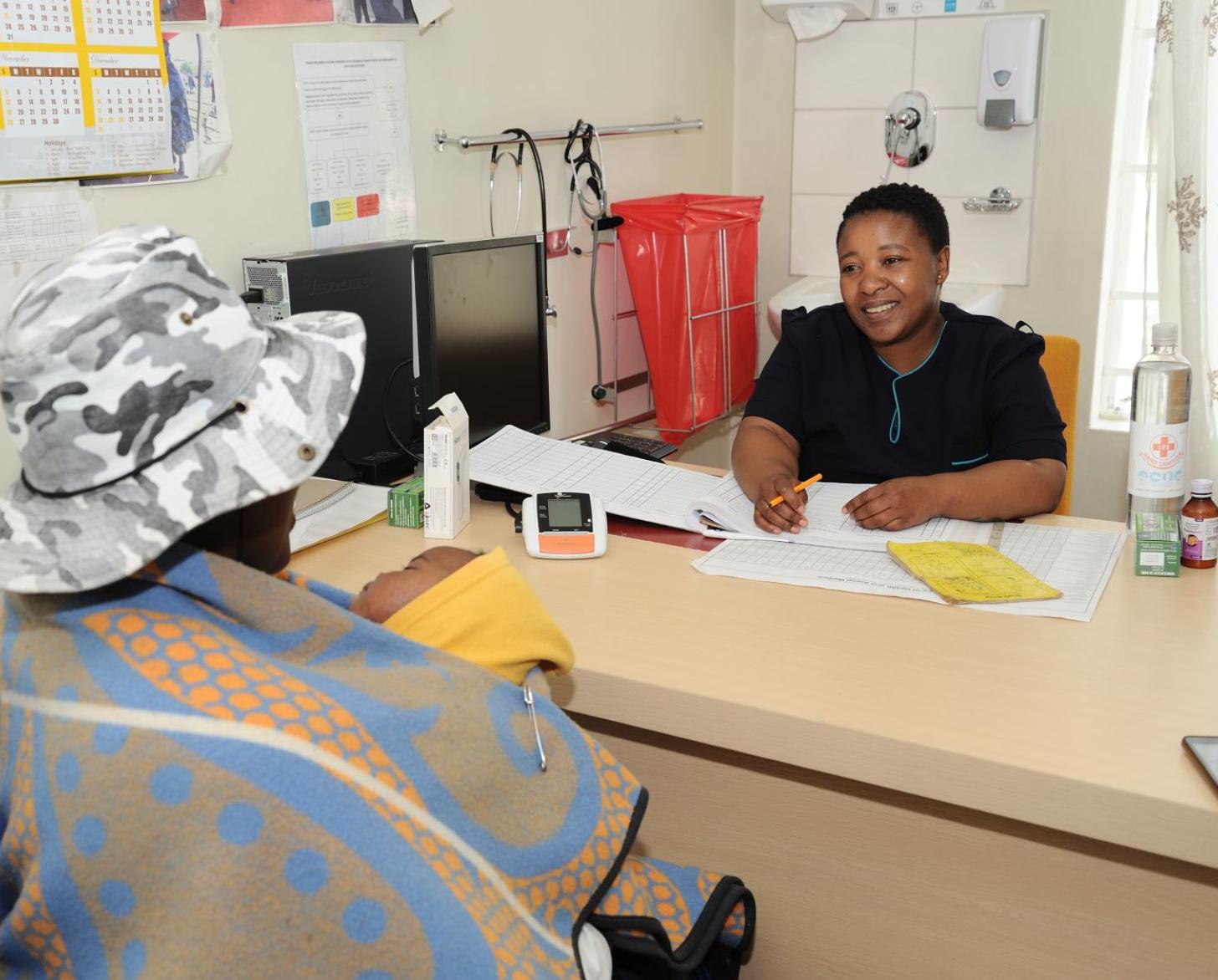 A woman is seated in front of a doctor