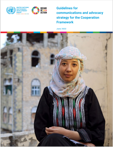 امرأة تجلس أمام مبنى مدمر في الخلفية.