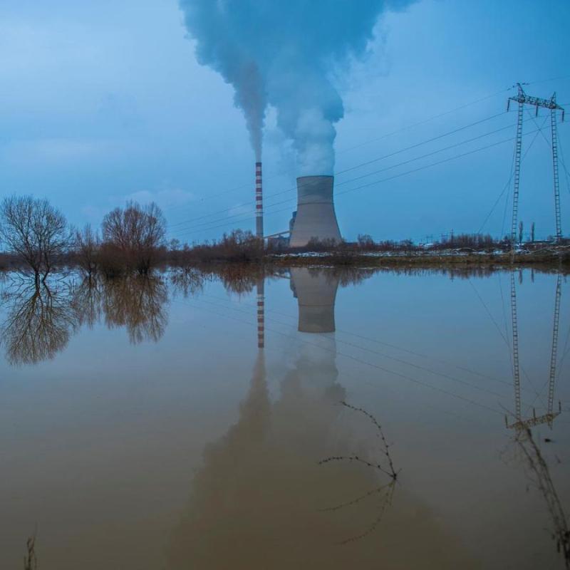 شوارع غمرتها المياه بالقرب من أحد المصانع وقت غروب الشمس.